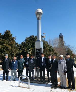 雪が残る電子基準点で集合写真撮影