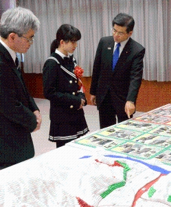 写真:石井国土交通大臣に作品の説明をする志津野さん