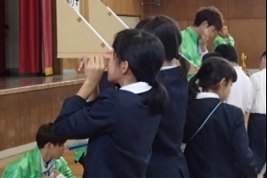 写真:体育館において測量体験学習(三角定規を使った高低差測量)