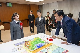写真：赤羽国土交通大臣に作品の説明をする荒井さん